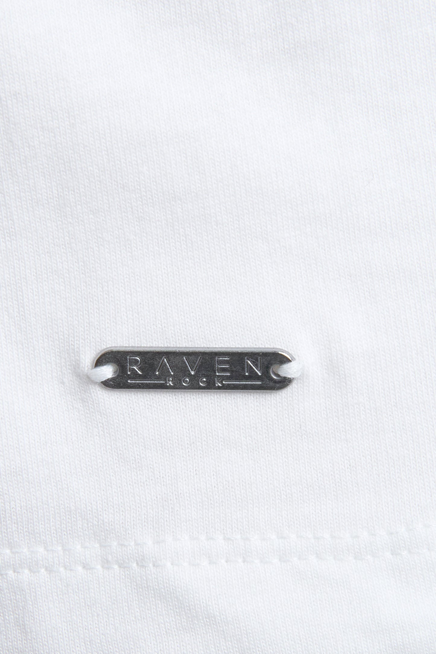 Close-up of a white denim fabric with 'RAVEN ROCK' branding