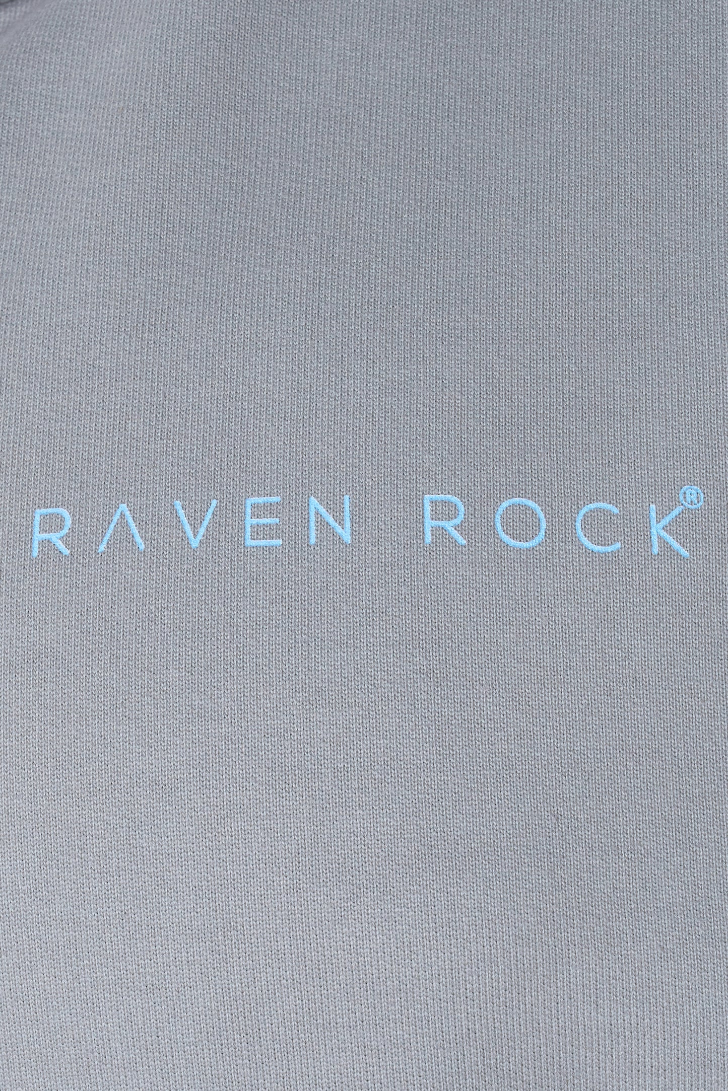 Close-up of RAVEN ROCK printed logo on grey hoodie chest – made in the UK, traceable cotton