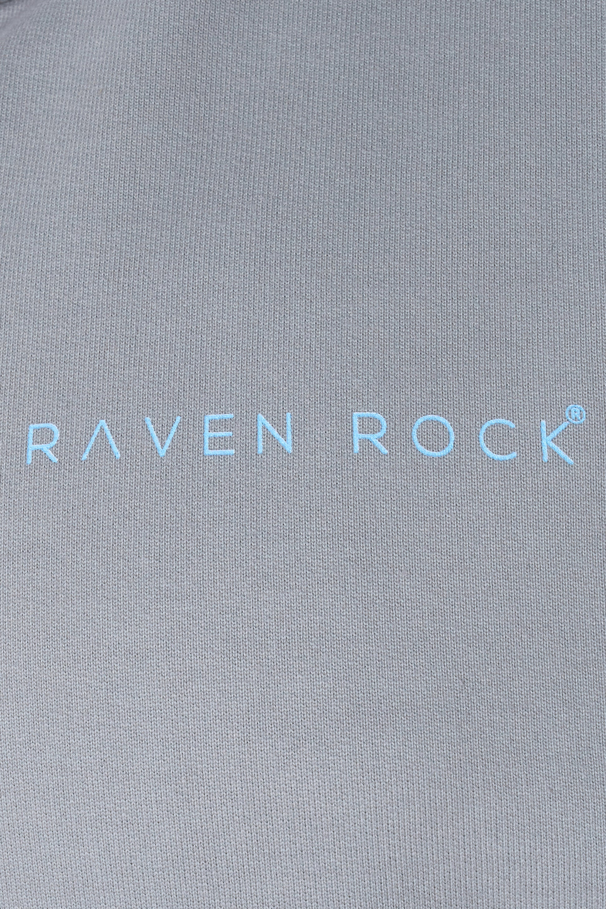 Close-up of RAVEN ROCK printed logo on grey hoodie chest – made in the UK, traceable cotton