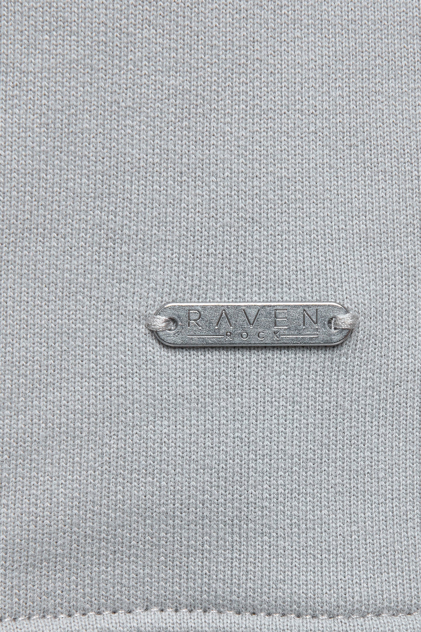 Close-up of metal tag with RAVEN ROCK branding.