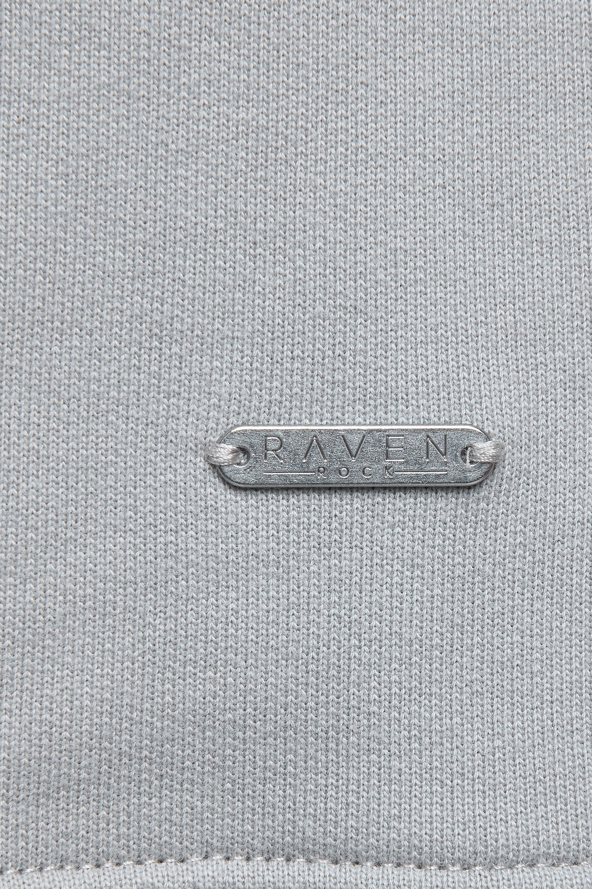 Close-up of metal tag with RAVEN ROCK branding.