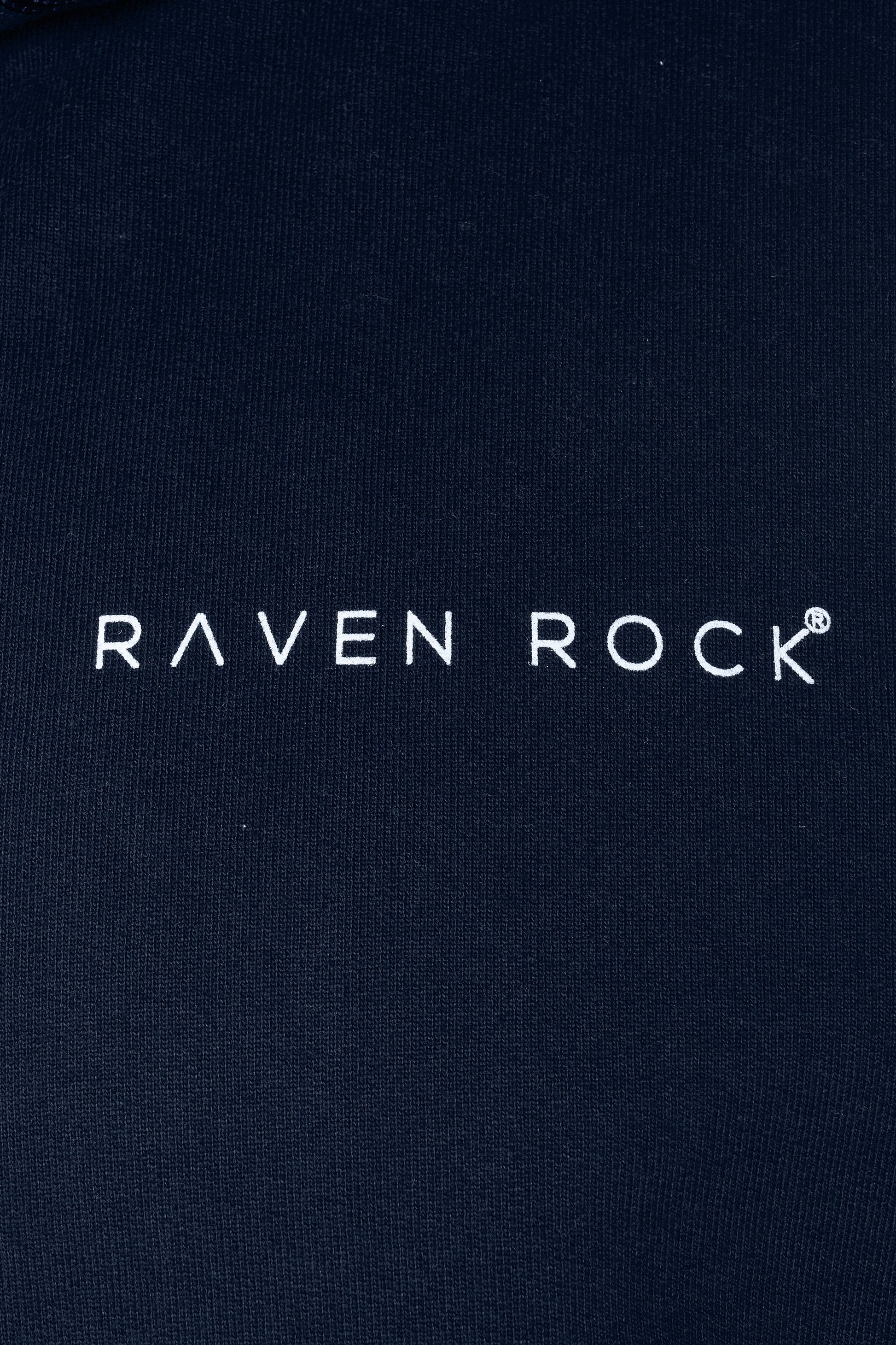 Close-up of RAVEN ROCK chest logo on navy hoodie – made in the UK from traceable cotton