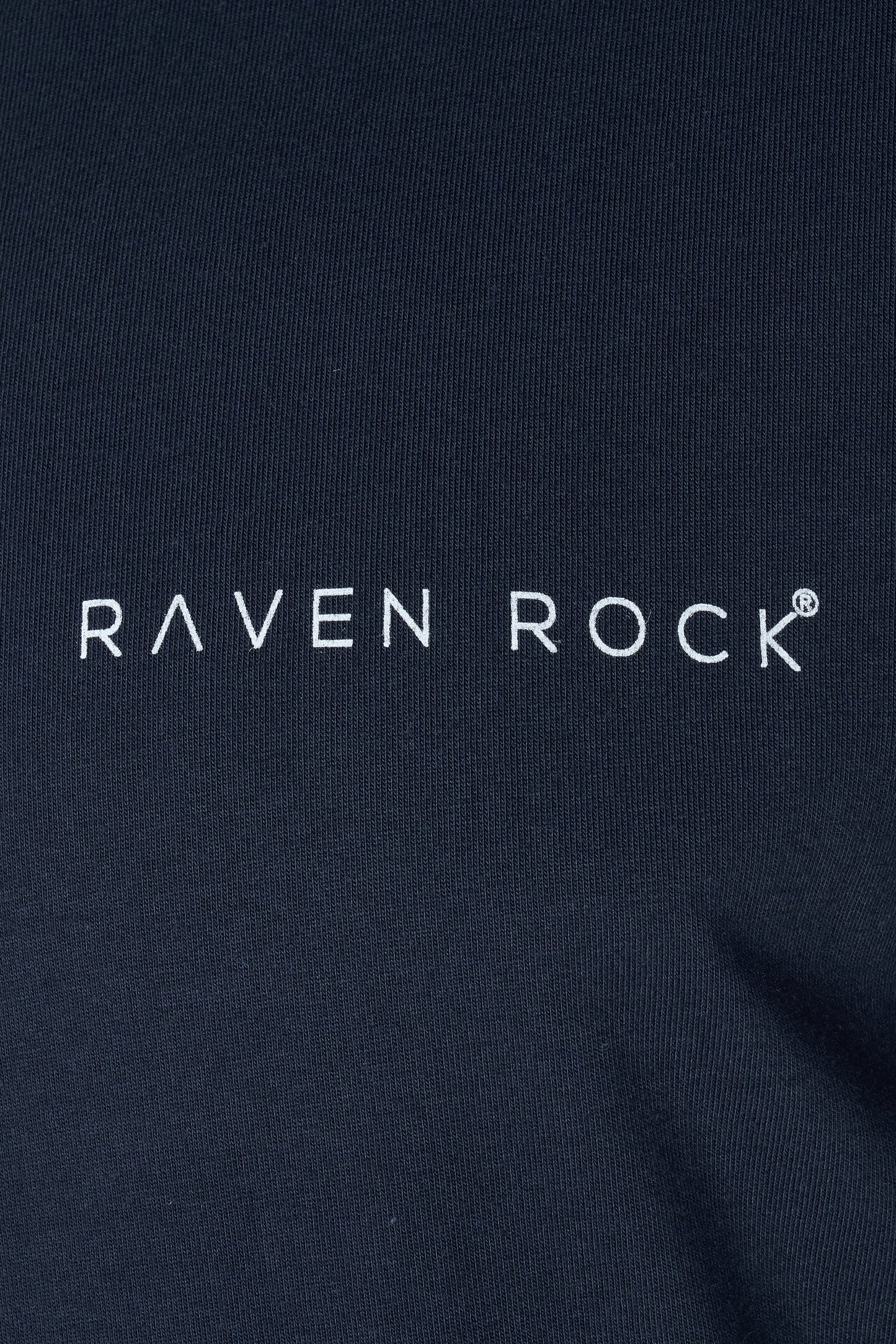 Close-up of subtle RAVEN ROCK chest logo on navy t-shirt – made in Britain, traceable cotton