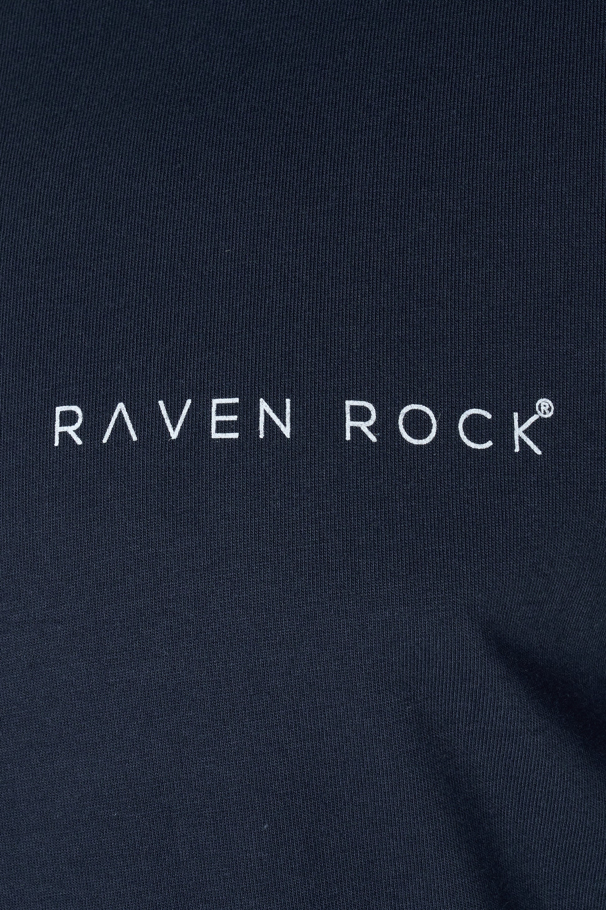 Close-up of subtle RAVEN ROCK chest logo on navy t-shirt – made in Britain, traceable cotton