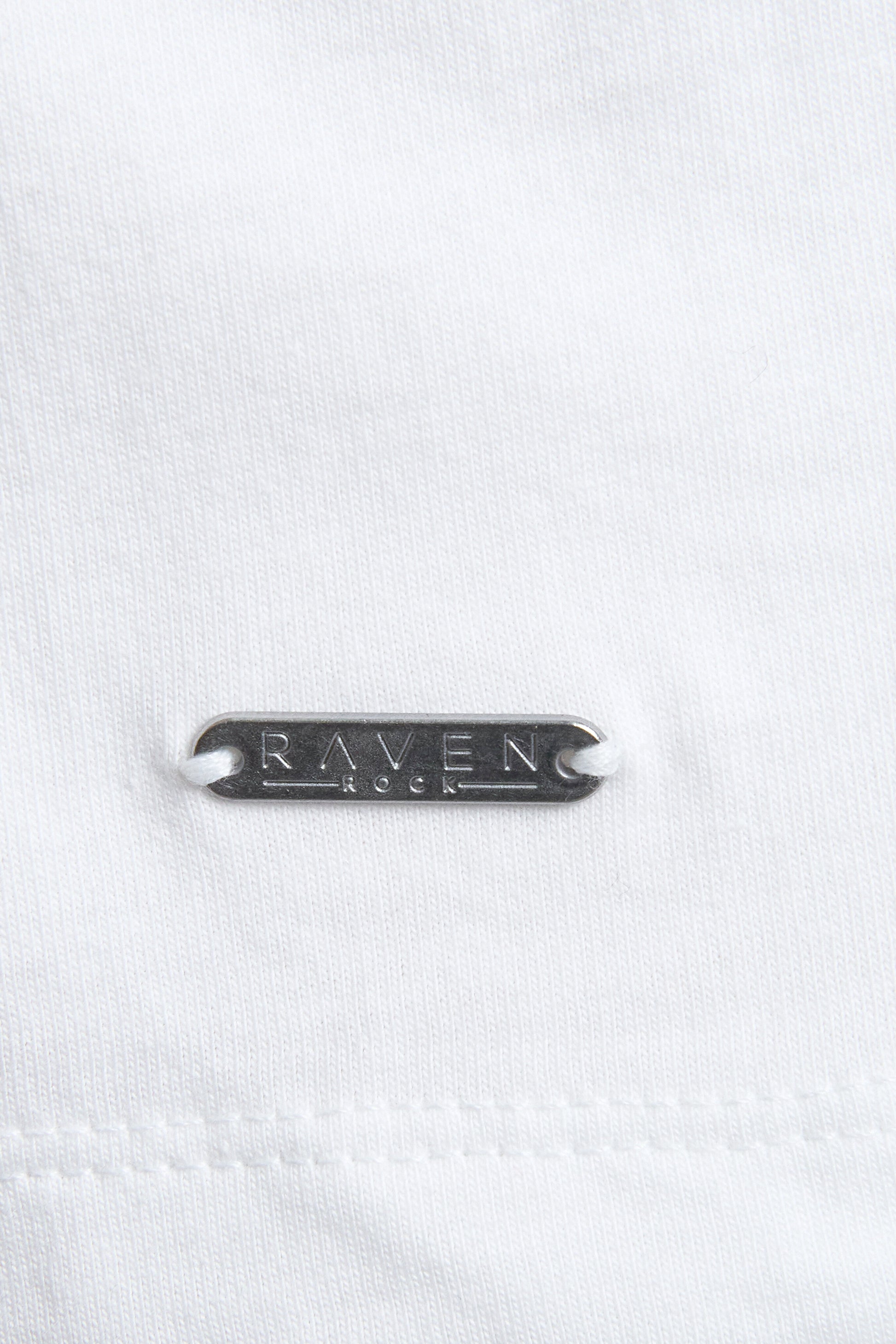 Close-up of a white denim fabric with 'RAVEN ROCK' branding