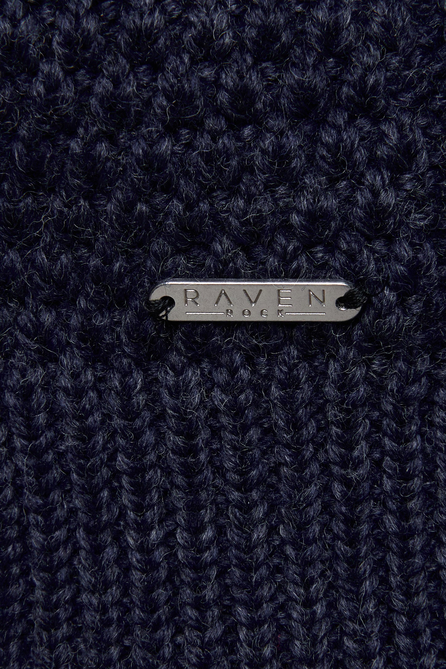 Close-up of a dark blue wool yarn  with 'RAVEN ROCK' branding.
