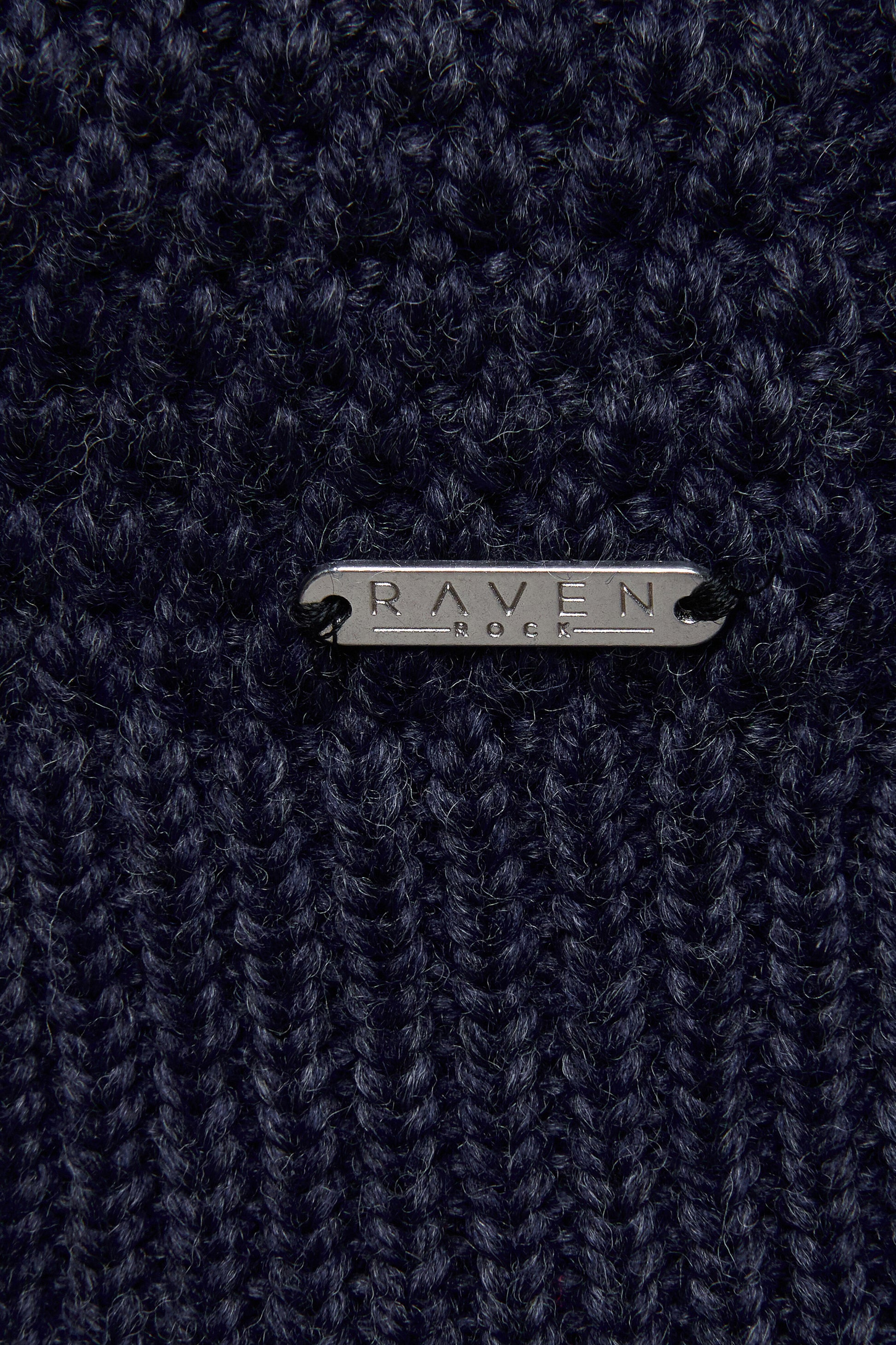 Close-up of a dark blue wool yarn  with 'RAVEN ROCK' branding.